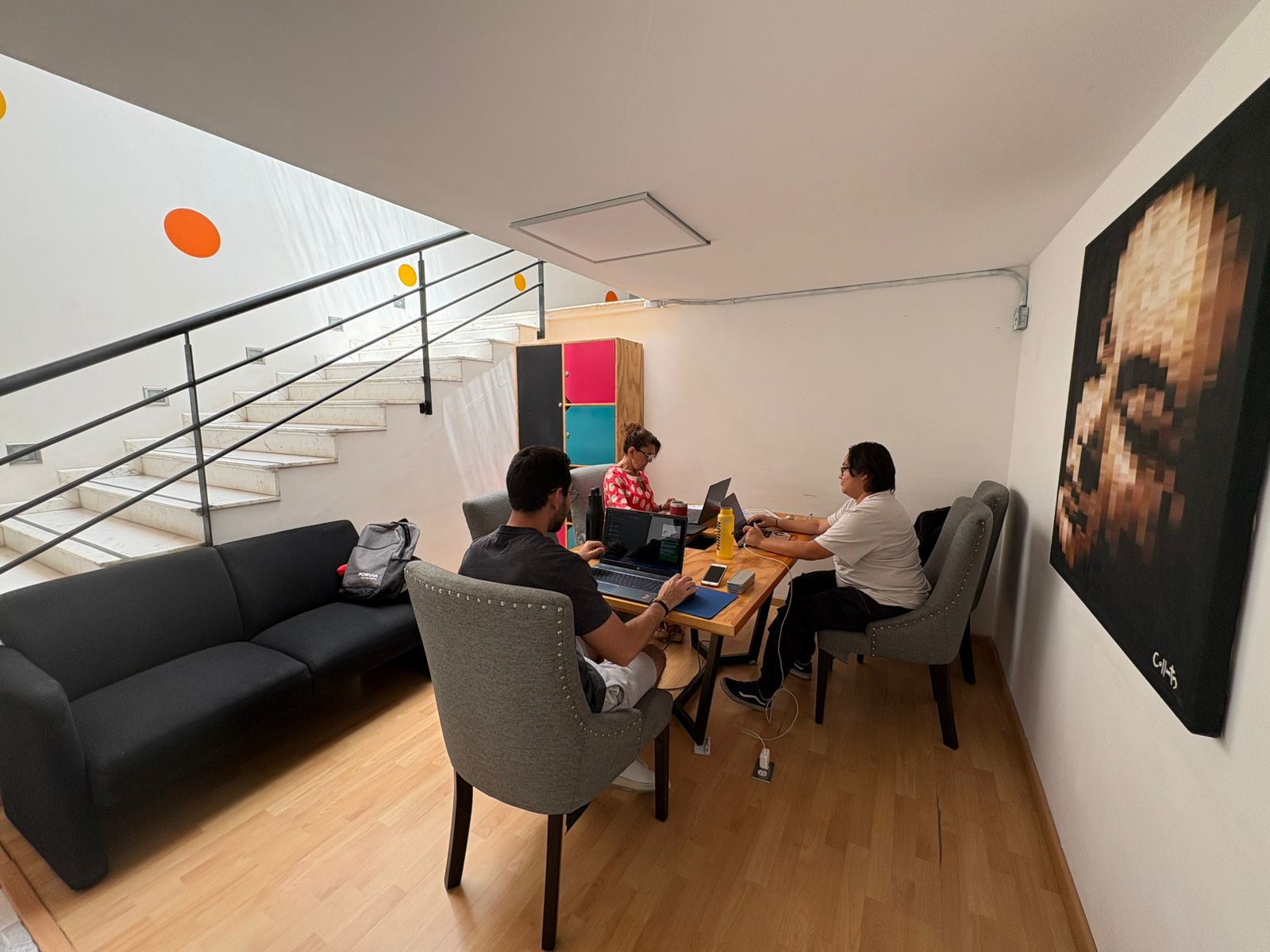Workósfera Coworking — mesa compartida con personas trabajando en laptops