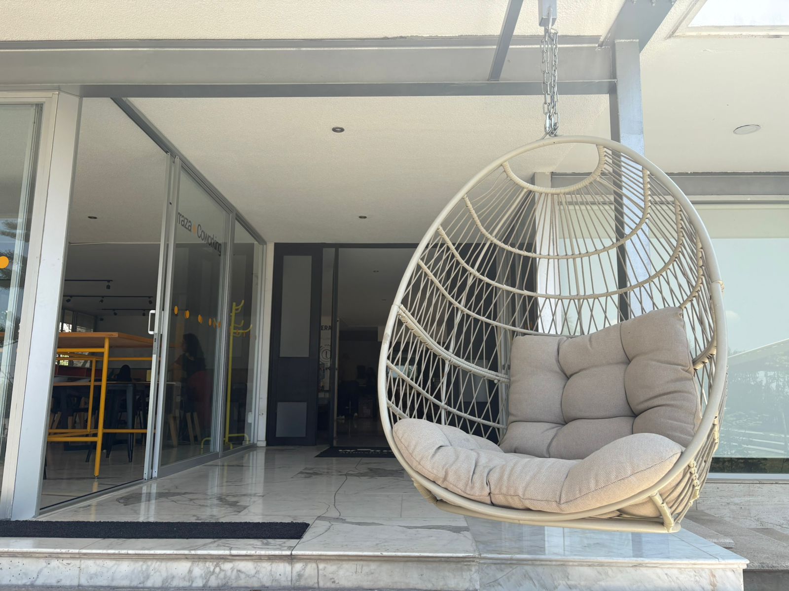 Workósfera Coworking — terraza con silla colgante y acceso Terraza Coworking